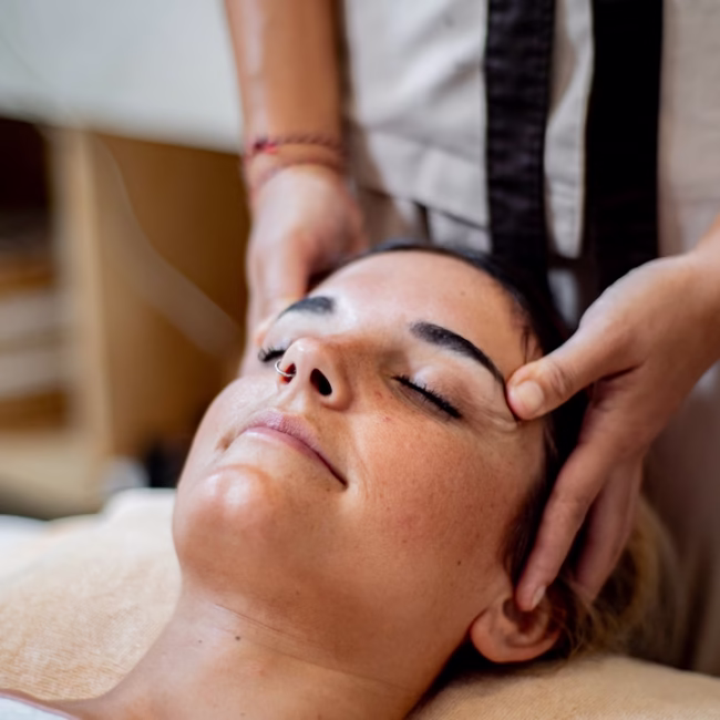 Woman receiving massage ubud bali spa treatment in open tropical pavilion