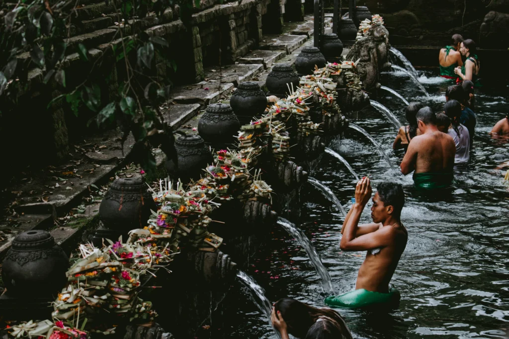Balinese priest performing melukat purification ritual at Tirta Empul temple