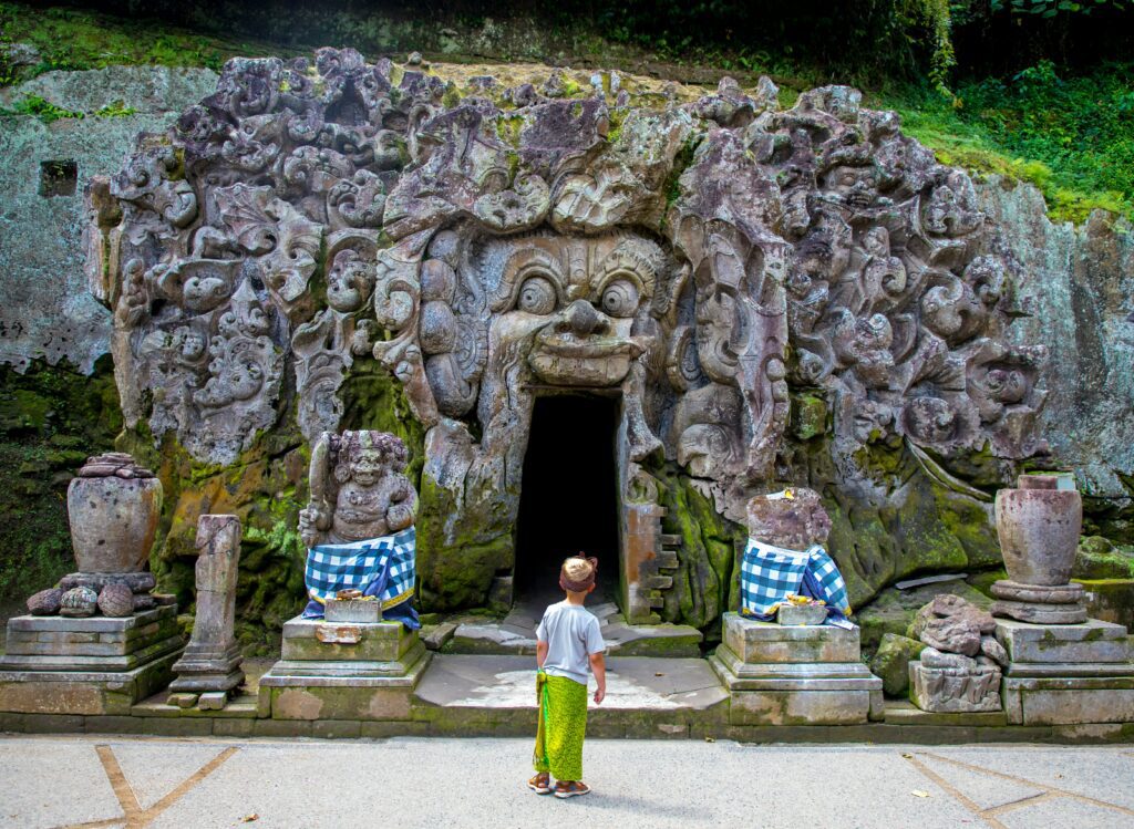 Ancient stone carvings of the barong face entrance at the historic Goa Gajah Elephant Cave in Ubud