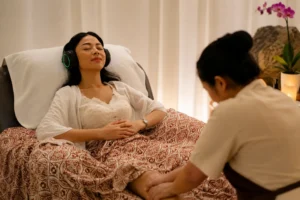 Woman relaxing with headphones during a calming foot massage treatment at a luxury spa.